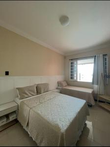 Un dormitorio con una cama y un sofá y una ventana. en Hostel beach, en Aracaju