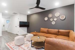 uma sala de estar com um sofá castanho e uma televisão de ecrã plano em Boho Ferry- Mins from Credit One- Pet Friendly em Charleston