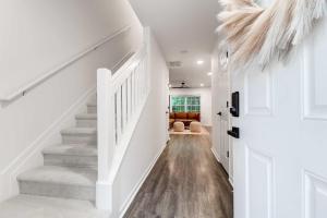 a hallway with white walls and a stairway with white stairs at Boho Ferry- Mins from Credit One- Pet Friendly in Charleston