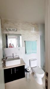 une salle de bain avec toilettes, lavabo et miroir dans l'établissement Paraiso Caribeño 706, à Colón