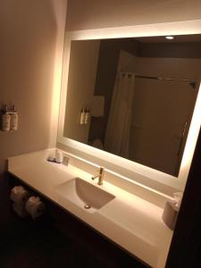 une salle de bain avec un lavabo et un grand miroir dans l'établissement Holiday Inn Express & Suites Bonham by IHG, à Bonham
