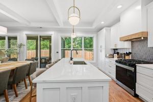 een keuken met een wit aanrecht en een tafel bij New Modern Luxurious Woodland Retreat home in Scottdale