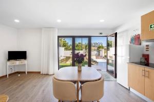 アプーリアにあるApartamento Lomi com Piscinaのテーブルと椅子のあるキッチンとダイニングルーム