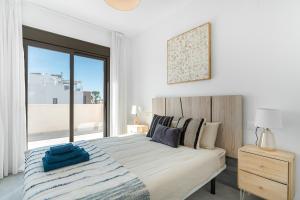 ein weißes Schlafzimmer mit einem großen Bett und einem Fenster in der Unterkunft Chalet con Piscina in Orihuela + 18 Fotos