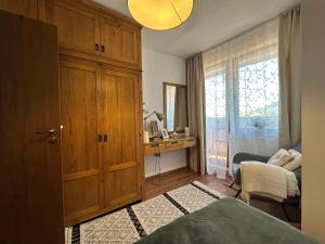 a bedroom with a wooden cabinet and a desk at Murphys Lodge panorama apartment in Bansko