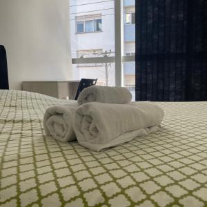 a pile of towels sitting on top of a bed at Pel Apart Hotel in Pelotas