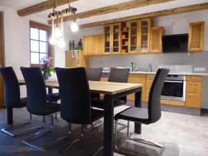 Una cocina con una mesa y sillas de madera. en Fischerhof, en Höchenschwand