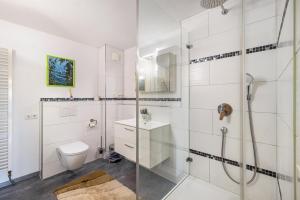 GäufeldenにあるFerienwohnung Gäufelden 120 Qmのシャワーとトイレ付きの白いバスルーム +20枚の写真