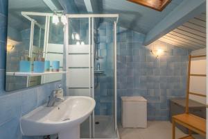 a blue bathroom with a sink and a mirror at L'olivier in Saint-Just +12 photos
