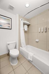 a bathroom with a toilet and a bath tub at Hilton Garden Inn New Braunfels in New Braunfels +28 photos