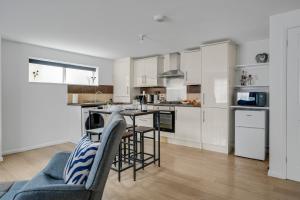 een keuken met witte kasten en een tafel en stoelen bij Bright 1-Bed Flat, Near Station, Fast Wi-Fi in Wellingborough +20 foto's