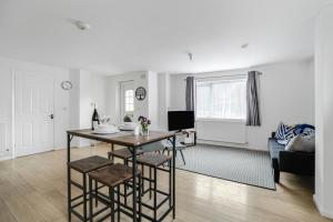 een woonkamer met een tafel en een bank bij Bright 1-Bed Flat, Near Station, Fast Wi-Fi in Wellingborough