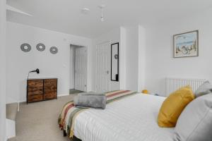 een witte slaapkamer met een groot bed en een dressoir bij Bright 1-Bed Flat, Near Station, Fast Wi-Fi in Wellingborough
