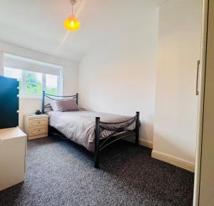 a bedroom with a bed and a window at 2 Beds, Entire Home, Spacious Bedrooms, Garden in Aberdulais