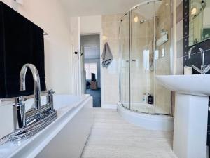 a bathroom with a sink and a tub and a shower at 2 Beds, Entire Home, Spacious Bedrooms, Garden in Aberdulais