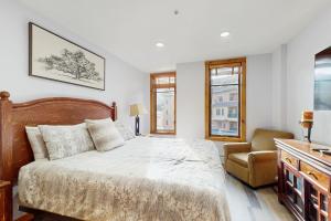 a bedroom with a bed and a chair at Main Street Station #2302 in Breckenridge +21 photos