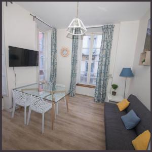 een woonkamer met een glazen tafel en een bank bij Le 14 De Pic in Cauterets