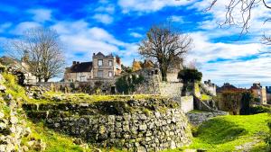 un vieux château sur une colline avec un mur de pierre dans l'établissement La maison au cœur médiéval, à Domfront