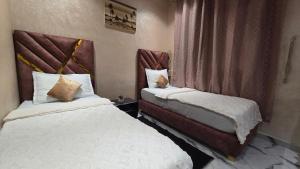 マラケシュにあるNear Airport hostingのベッドが2つと窓があるホテルの部屋