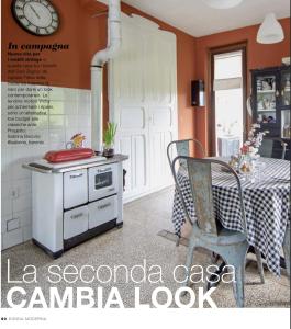 une cuisine avec une cuisinière et une table avec des chaises dans l'établissement Brockwood Manor Tea House - Valdilana, à Valle Mosso