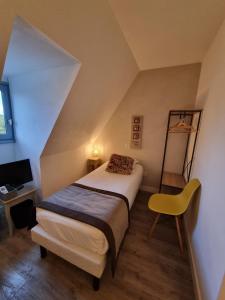 a bedroom with a bed and a yellow chair at Amadour Hôtel in Rocamadour +35 photos