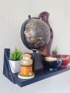 a shelf with a globe and a plant on it at Pomona Cozy Queen Bedroom in Pomona