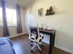 a desk with a chair in a room with a window at Pomona Cozy Queen Bedroom in Pomona