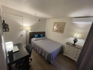 a hotel room with a bed and a desk and a desk at Pomona Cozy Queen Bedroom in Pomona