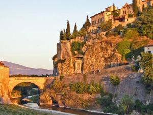 un pont sur une rivière avec des maisons sur une montagne dans l'établissement Maison proche Vaison la Romaine, à Saint-Romain-en-Viennois