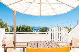 Un patio con una mesa y sillas y una sombrilla. en Sorokos Koufonissia, en Koufonisia