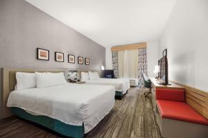 een hotelkamer met 2 bedden en een rode bank bij Hilton Garden Inn New Braunfels in New Braunfels +94 foto's