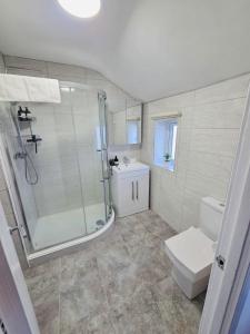 une salle de bains avec douche, toilettes et lavabo dans l'établissement 3 Bedroom Village Stay - Comfort & Charm in Yorkshire, à Kippax