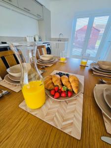 une table avec une assiette de nourriture et un verre de jus d'orange dans l'établissement 3 Bedroom Village Stay - Comfort & Charm in Yorkshire, à Kippax 22 autres photos