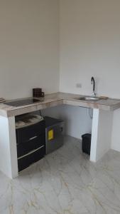 a kitchen counter with a sink in a room at Le jardin in Puerto López