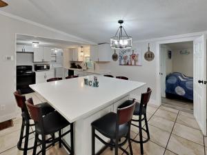 a kitchen with a white counter top and chairs at Put-in-Bay Island Club #66 in Put-in-Bay