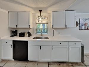 a kitchen with white cabinets and a sink at Put-in-Bay Island Club #66 in Put-in-Bay +25 photos