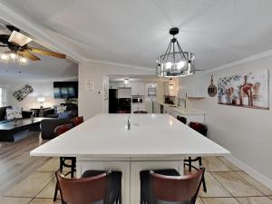 une cuisine et un salon avec une table et des chaises blanches dans l'établissement Island Club #66, à Put-in-Bay