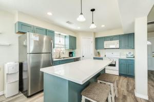 a kitchen with blue cabinets and a refrigerator at Blue Waves - Beachside Calm, Gulf Views for Miles in Freeport