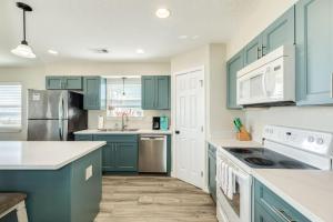 a blue kitchen with white appliances and blue cabinets at Blue Waves - Beachside Calm, Gulf Views for Miles in Freeport +33 photos