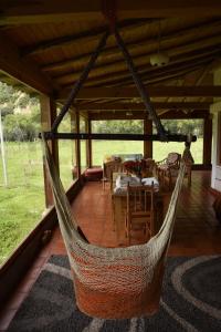 a hammock on a porch with a table and chairs at Casa de campo con vista al Huascarán in Huaraz +74 photos
