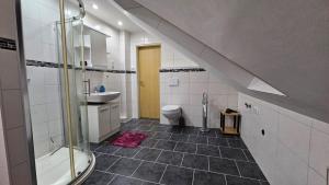 a bathroom with a sink and a shower and a toilet at Fewo Wilhelmshaven Langewerth in Roffhausen +24 photos