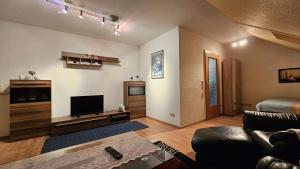 a living room with a couch and a flat screen tv at Fewo Wilhelmshaven Langewerth in Roffhausen