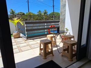 a balcony with a bench and a table and stools at Freesia Apartment 3 by Mau-Rent Houses in Trou aux Biches