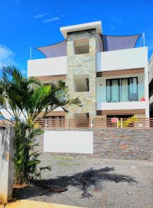 a building with a palm tree in front of it at Freesia Apartment 3 by Mau-Rent Houses in Trou aux Biches