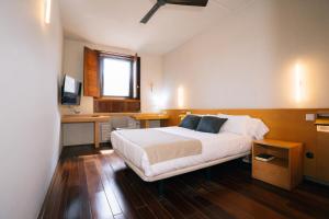 a bedroom with a bed and a desk with a computer at Hostatgeria de Poblet in Poblet +62 photos