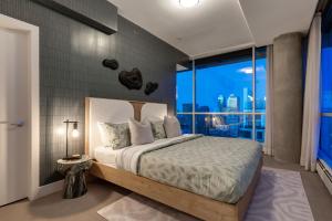 a bedroom with a bed and a large window at 2 Storey Penthouse Panoramic Views Parking Stampede in Calgary +20 photos