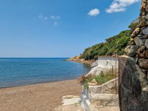 NisportoにあるCasa Cristina con patio privatoの石壁と海のビーチ