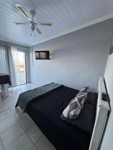 モッセル・ベイにあるLion's Cave 2のベッドルーム1室(黒いベッド1台、天井ファン付)