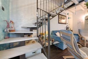 une pièce avec un escalier et un canapé bleu dans l'établissement Villa La Baia, à San Felice del Benaco