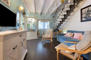 - un salon avec un canapé bleu et des escaliers dans l'établissement Villa La Baia, à San Felice del Benaco